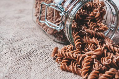 Mutfaktaki çarşaf örtüsünün üzerinde bir tabak çiğ makarna.