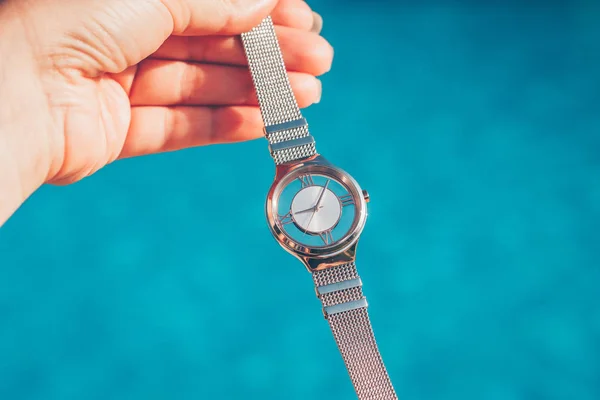 Fashionable wrist watch on the background of the pool