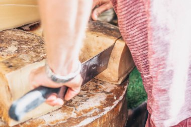 Piyasadaki bir peynir tüccarı alıcı için büyük bir peynir parçasını keser.