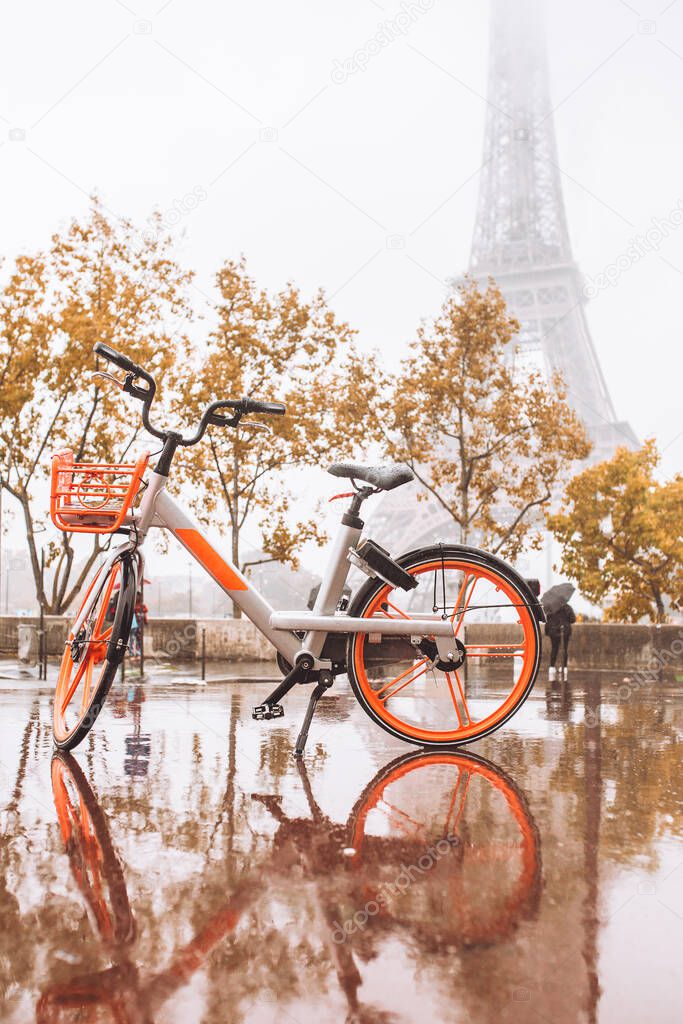 Heavy rain in Paris - bad weather for cycling - a bicycle against the eiffel tower