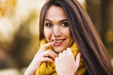 Şakacı esmer parmağını ısırır - yüzünde mutlu bir gülümsemeyle flört eder.