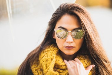 Uzun, kalın saçlı ve güneş gözlüklü muhteşem esmer. Ruh hali.
