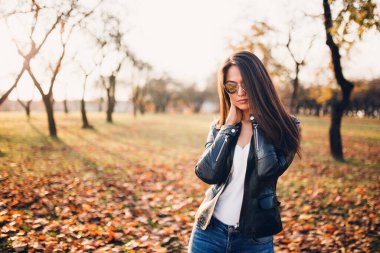 İnce, uzun saçlı, kotlu, ince esmer ve sonbahar ormanında bir ceket.