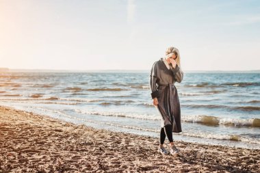 Yalnızlık ve huzur içinde boş kumlu bir sahilde yürüyen seksi, lüks sarışın. Aklını başına topla.