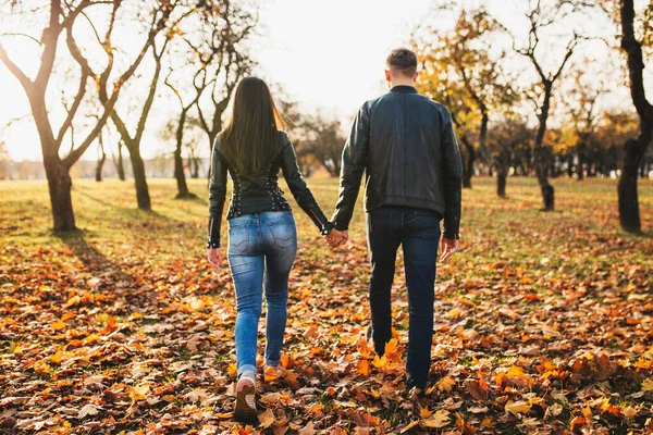 スレンダーアスレチック男と女の子は秋の森の中で手を取り合って距離に入る — ストック写真