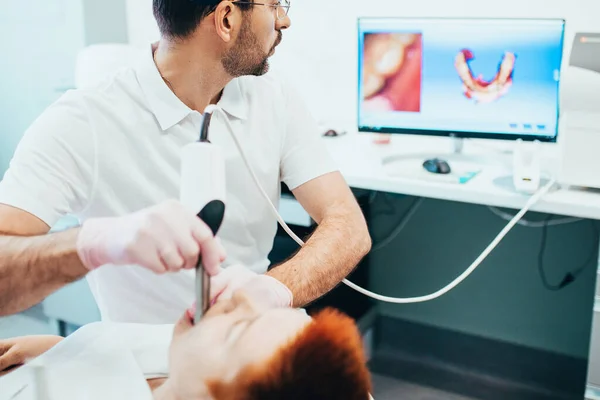 The dentist scans the jaw and creates a 3D model on the computer for the manufacture of a denture