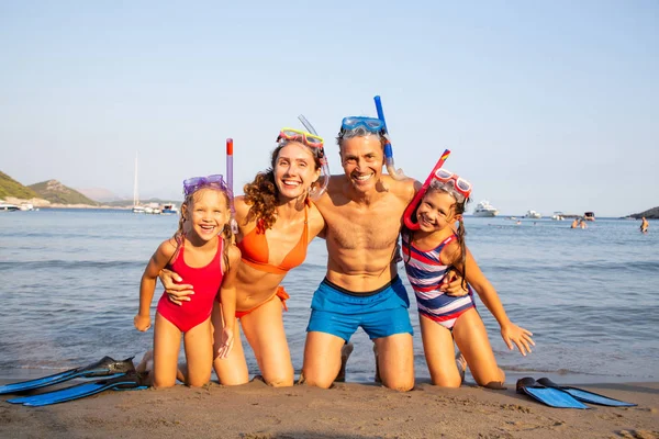 フィンとダイビングのマスクを持つ海リゾートのビーチで一休み幸せな家族の肖像画 — ストック写真