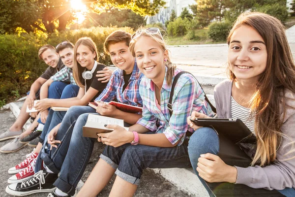 Grupa Młodych Studentów Książkami Gadżetami Siedzi Schodach Parku — Zdjęcie stockowe