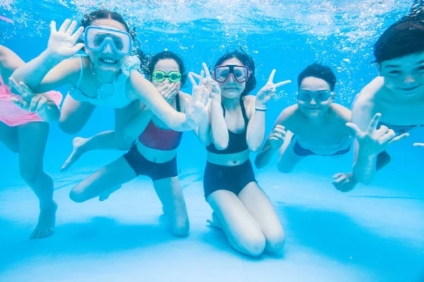 小さな子供たちが水中プールで泳ぎ — ストック写真