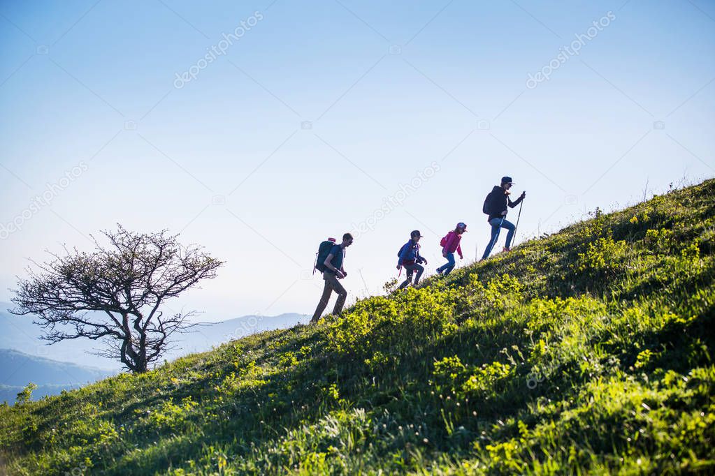  family with two kids have hiking  through the mountains