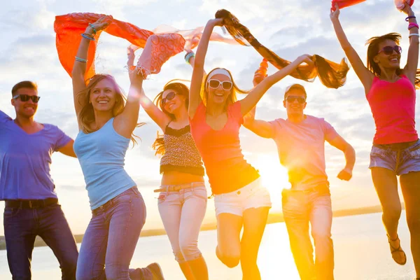幸せな若い人たちの美しい夏の日没浜のダンスのグループ — ストック写真