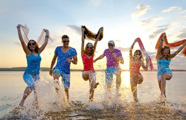 Fiatalok Fut Permetezés Szép Nyári Időben Strandon — Stock Fotó