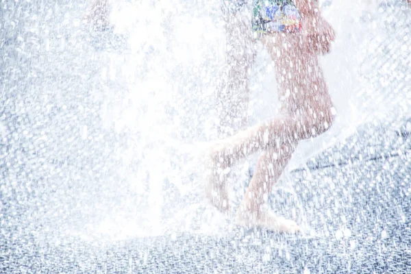 通りの噴水の水しぶきで遊ぶ子供たち — ストック写真