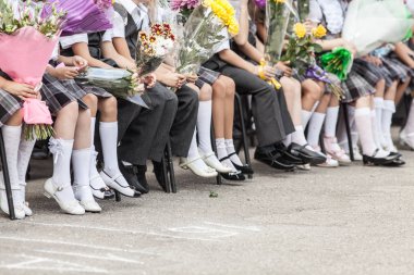 ilk-Greyder bir okul Event'de çiçekli okul üniformalı çocuklarının kümesi ayaklar