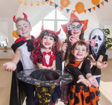 Kostümlü bir grup komik çocuk Cadılar Bayramı partisini birlikte kutluyor.
