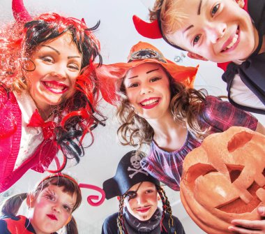 Kostümlü bir grup komik çocuk Cadılar Bayramı partisini birlikte kutluyor.
