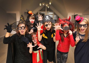 Kostümlü bir grup komik çocuk Cadılar Bayramı partisini birlikte kutluyor.