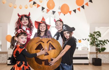 Kostümlü bir grup komik çocuk Cadılar Bayramı partisini birlikte kutluyor.