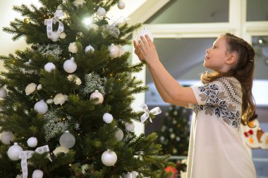 Küçük kız evde bir Noel ağacı süsle
