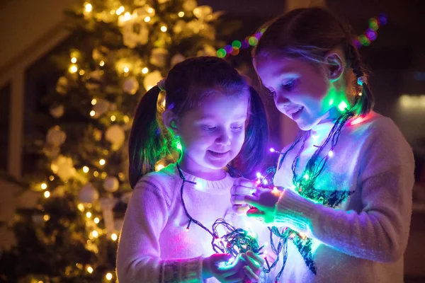 女の子を飾るクリスマス ツリーの電球 — ストック写真