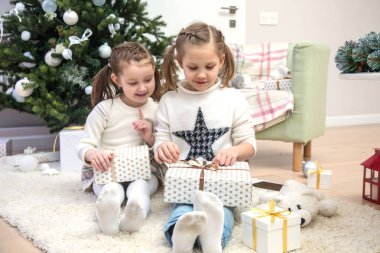 Noel ağacının altında küçük kızlar