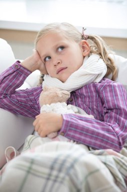 küçük kız hasta ve evde kanepede yatıyor
