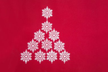 Kırmızı bir arka plan üzerinde dekoratif kar taneleri güzel Noel ağacı