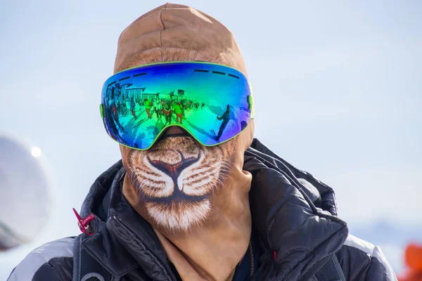 unrecognizable man in a ski mask and hat looks like a lion in a ski resort