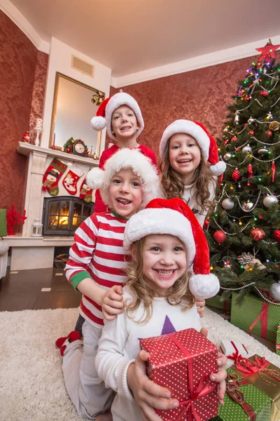 Mutlu Çocuklar Noel Ağacının Altında Şömine Yakın Noel Kutlamaları — Stok fotoğraf