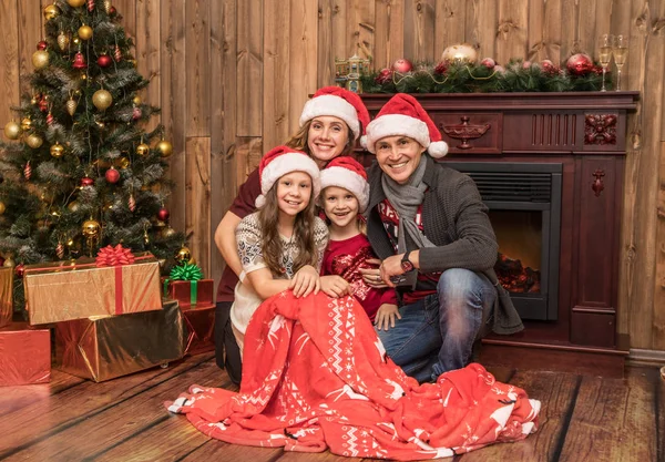 happy family celebrating Christmas near the fireplace under the Christmas tree