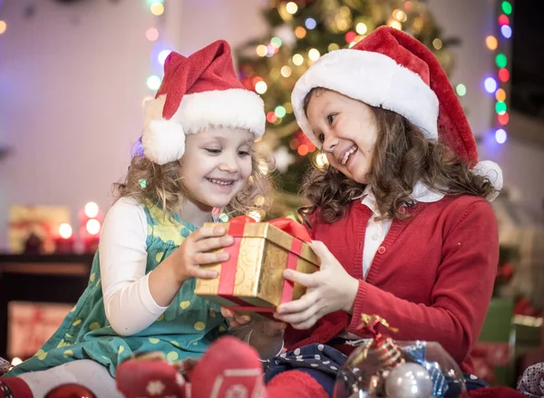 Noel Baba Şapkalı Iki Küçük Kız Noel Partisinde Hediyelerle — Stok fotoğraf