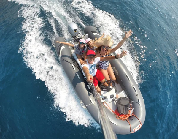 family with children sailing on an inflatable motorboat in the sea