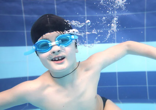 Niño nadando en la piscina bajo el agua. — Foto de Stock