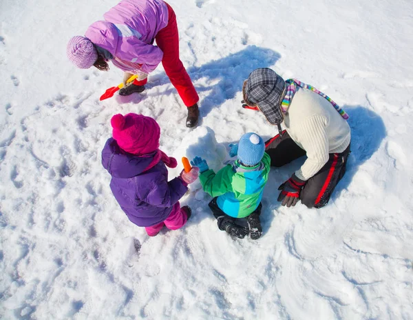 Счастливая Пара Двумя Детьми Делающими Большого Снеговика — стоковое фото