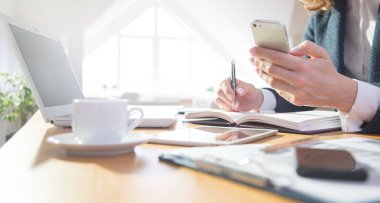 Dizüstü bilgisayar ve telefon ofiste çalışan iş kadını elinde