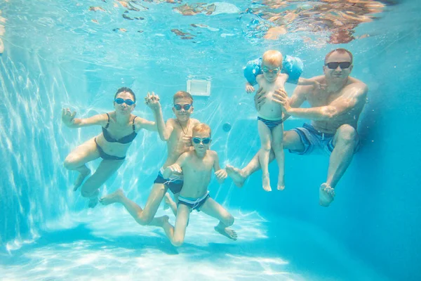 大年轻家庭和孩子们在游泳池里的水下照片 — 图库照片