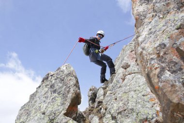 Dağcı kadın, karlı dağların arka planındaki dağdan iner.