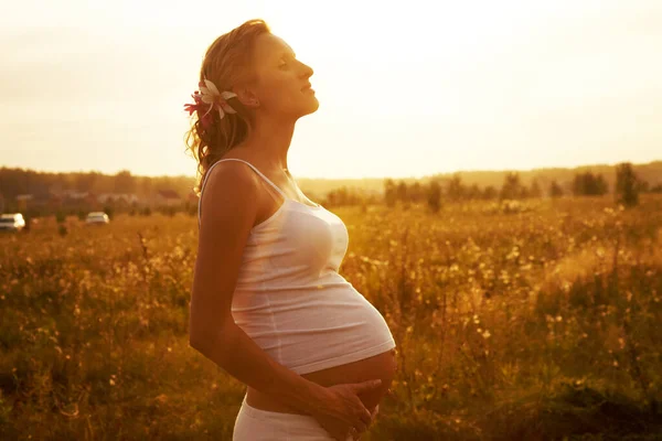 Těhotná Žena Drží Své Břicho Hřišti Při Západu Slunce — Stock fotografie