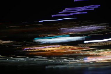 Renkli ışıkların inanılmaz soyut fotoğrafı koyu bir arkaplanda hareket halindeyken bulanıklaşıyor