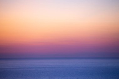 Gün batımında sakin bir denizde güzel bir ufuk manzarası.