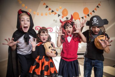 Kostümlü bir grup komik çocuk Cadılar Bayramı partisini birlikte kutluyor.