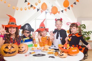 Kostümlü bir grup komik çocuk Cadılar Bayramı partisini birlikte kutluyor.