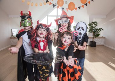 Kostümlü bir grup komik çocuk Cadılar Bayramı partisini birlikte kutluyor.