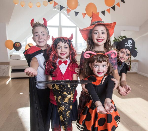 group of funny  children in costume celebrate together a halloween party