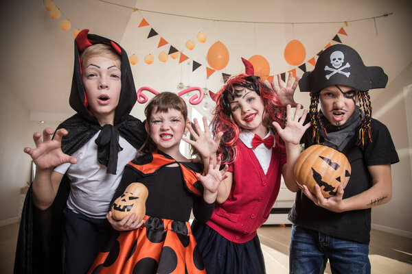 group of funny  children in costume celebrate together a halloween party