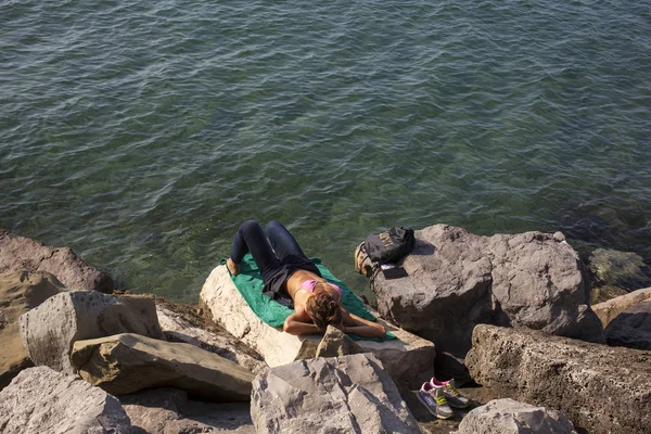 Kayanın üzerinde Bronzlaştırıcı güzellik kız — Stok fotoğraf