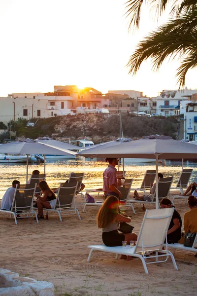 Люди, сидящие на шезлонгах в пляжном баре, Lampedusa — стоковое фото