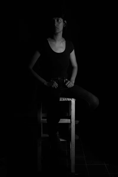 Black and white portrait of a girl sitting on a stool