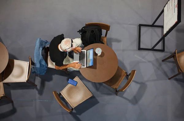 トリエステ イタリア 2020 9月6日にトリエステで開催されたEuroscienceオープンフォーラムのEsof中にプレスルームでノートブックを操作するテーブルに座っている男のトップビュー ストックフォト