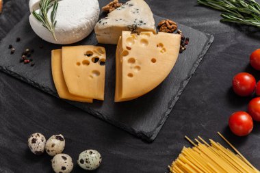 Siyah masanın üstünde farklı besin maddeleri olan peynir koleksiyonu.